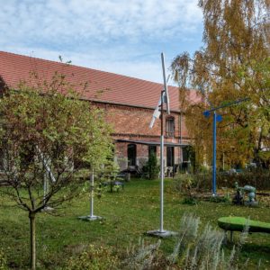 Kunsttour Betzin-Brunne - Die Skulpturen im Garten und Werkstatt im Hintergrund